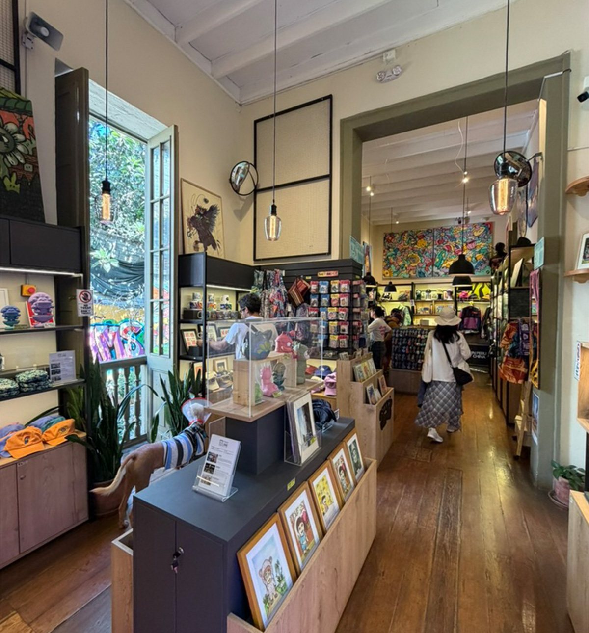 Interior de Espacio Unno en Barranco: repisas con prints, art toys y ropa, con clientes mirando