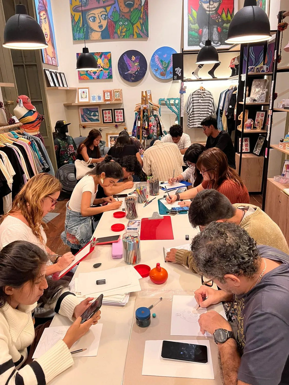 La mesa larga del taller llena de gente dibujando durante la Semana Espacio Unno